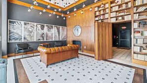 A modern library with a leather sofa, bookshelves, and a fireplace. - FIFA 10 Mins Away | Rooftop | Gym | King bed (Philadelphia)
