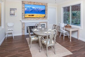 A dining room with a fireplace, a large painting, and a view through a window. - Coto De Caza Modern Home, Golf Course View (Coto de Caza)