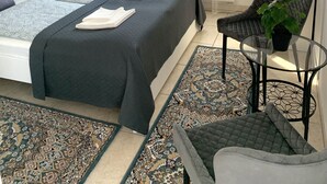A modern bedroom with a large bed, a small table, a chair, and a window with sheer curtains. - Double bedroom in historical Villa in perfect location (Keszthely)