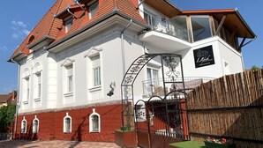 A two-story building with a red-tiled roof, white walls, and a balcony. - Double bedroom in historical Villa in perfect location (Keszthely)