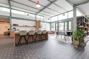 A spacious kitchen area with a central island, bar stools, and pendant lighting.
