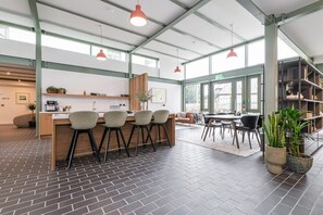 Une cuisine spacieuse avec un îlot central, des tabourets de bar et des luminaires suspendus.