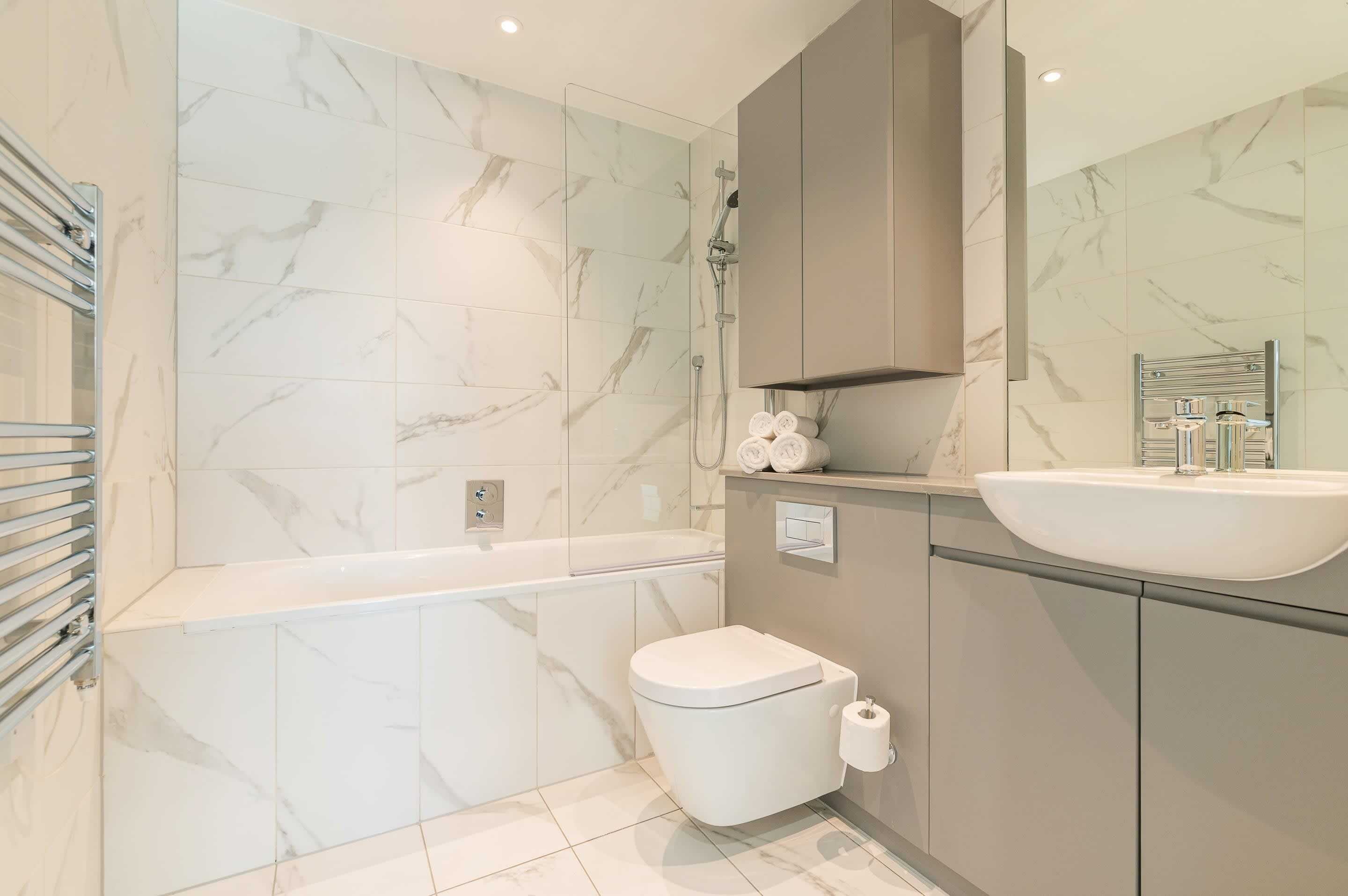 Une salle de bain moderne équipée d’une baignoire, de toilettes et d’un lavabo.