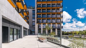 En modern byggnad med flera våningar, stora fönster och en klar himmel.