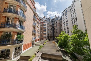 Un patio con edificios de varios pisos, balcones y una pequeña fuente.