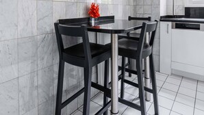 A modern kitchen with a marble backsplash, a black dining table with chairs, and a dishwasher. - 3 pieces Arc de triomphe Champs Elysée - Paris 16 (Paris)