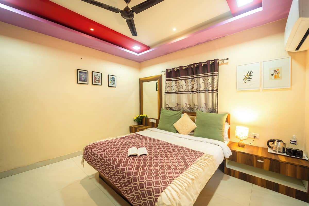 A neatly arranged bedroom with a bed, bedside table, lamp, and a ceiling fan.