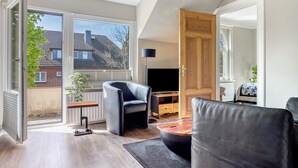 Ein modernes Wohnzimmer mit einer Couch, einem Couchtisch, einem Fernseher und einem Holzschrank.