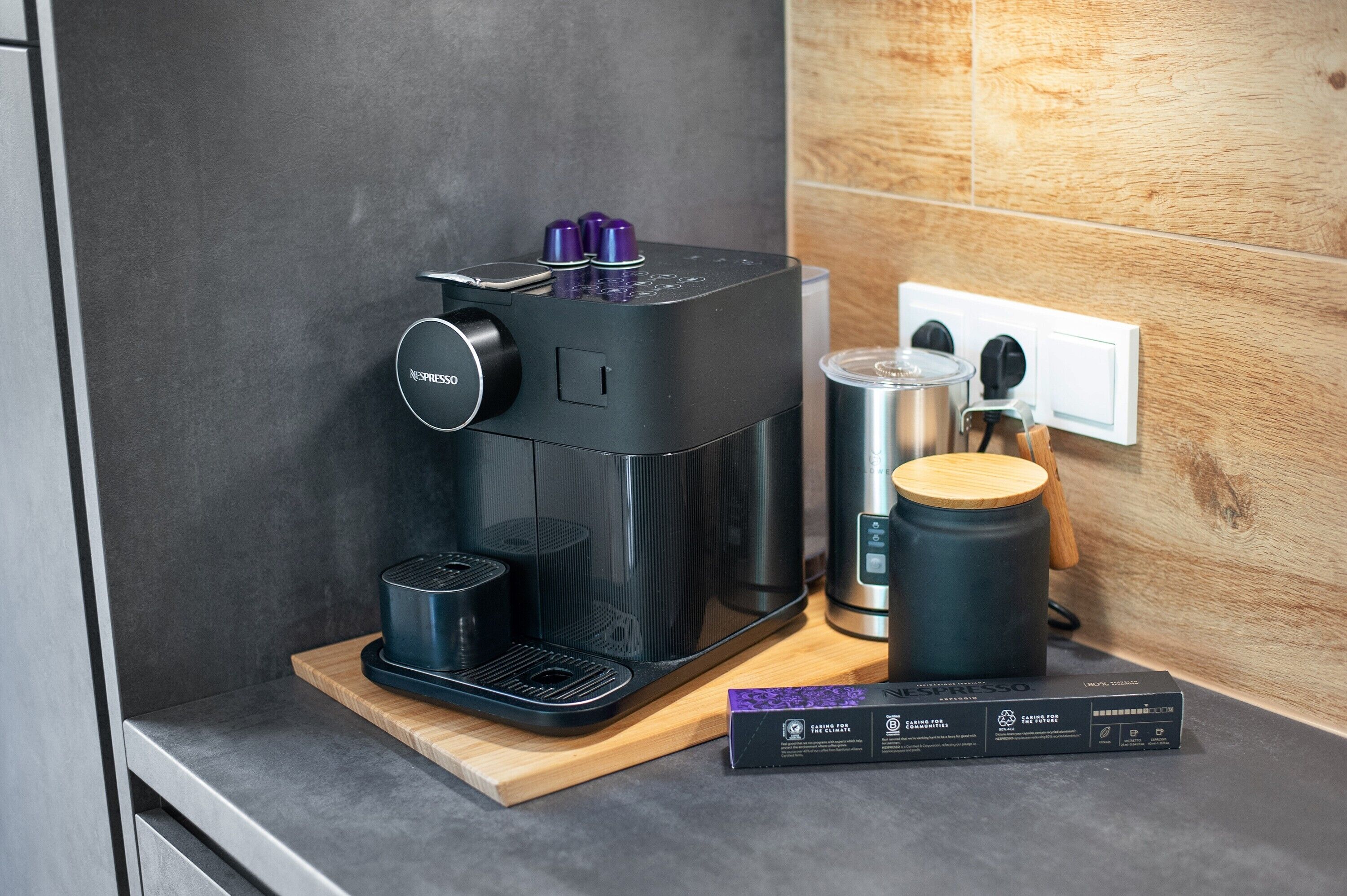 Eine moderne Kaffeemaschine mit Bedienfeld, Kaffeekanne und einer Box auf einer Arbeitsplatte.