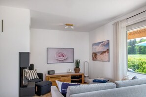A modern living room with a sofa, a coffee table, a TV stand, and artwork on the walls.