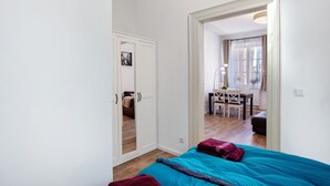 Um quarto com uma cama, uma escrivaninha e uma cadeira no cômodo ao lado.