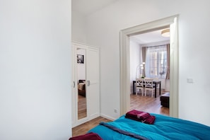 Une chambre à coucher avec un lit, un bureau et une chaise dans la pièce adjacente.