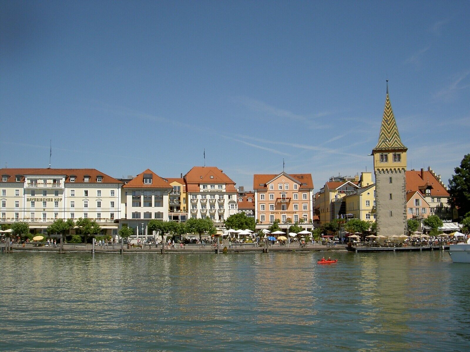 A waterfront cityscape with historic buildings, a prominent tower, and a calm river.