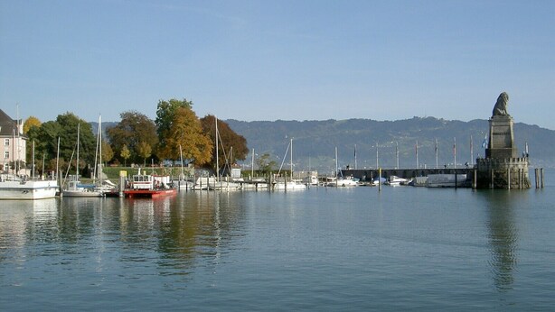 A marina with boats, a statue, and a bridge. - Holiday Apartment 'Dinkelbach Landhaus 1 A Charmant' with Lake View, Balcony and Wi-Fi (Bodolz)