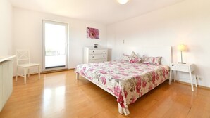 A bedroom with a bed, a chair, a dresser, a lamp, and a painting on the wall. - Holiday Apartment 'Dinkelbach Landhaus 1 A Charmant' with Lake View, Balcony and Wi-Fi (Bodolz)