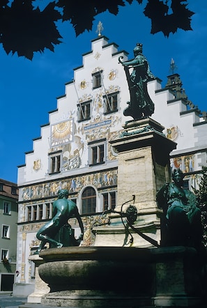Un edificio con detalles arquitectónicos ornamentales, incluyendo estatuas y elementos decorativos.