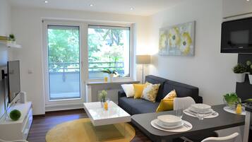 Uma sala de estar moderna com sofá, mesa de centro e mesa de jantar.