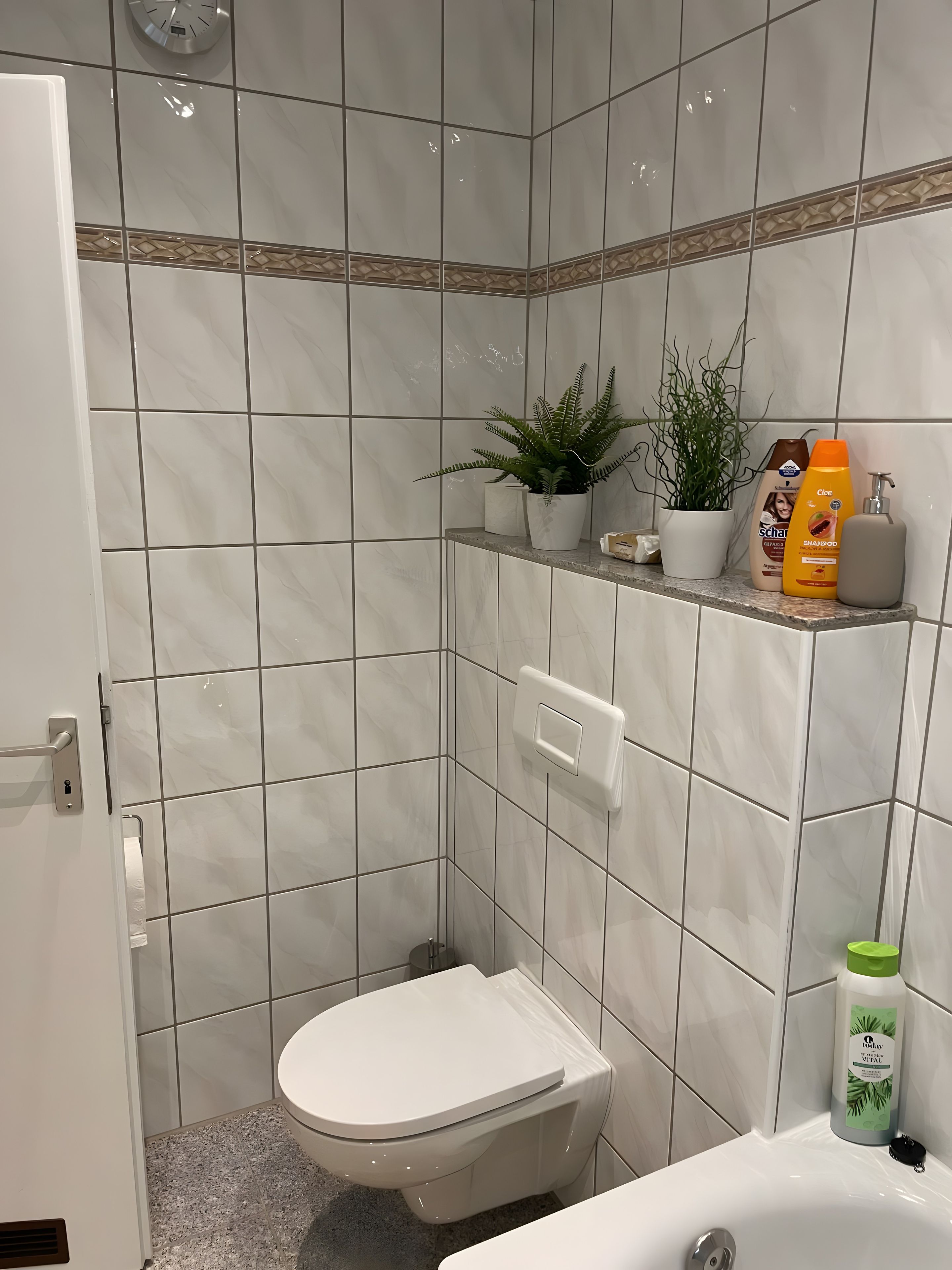 Ett badrum med toalett, handfat och en duschhörna.
