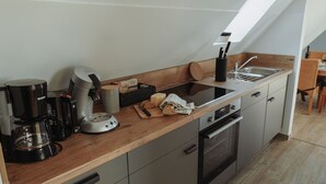 A modern kitchen with a built-in oven, a coffee maker, and a knife block.