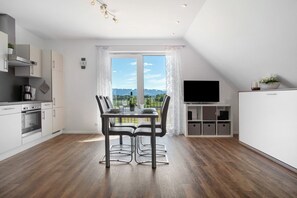 Eine moderne Küche mit Essbereich, einem Fernseher und Blick auf die Berge.