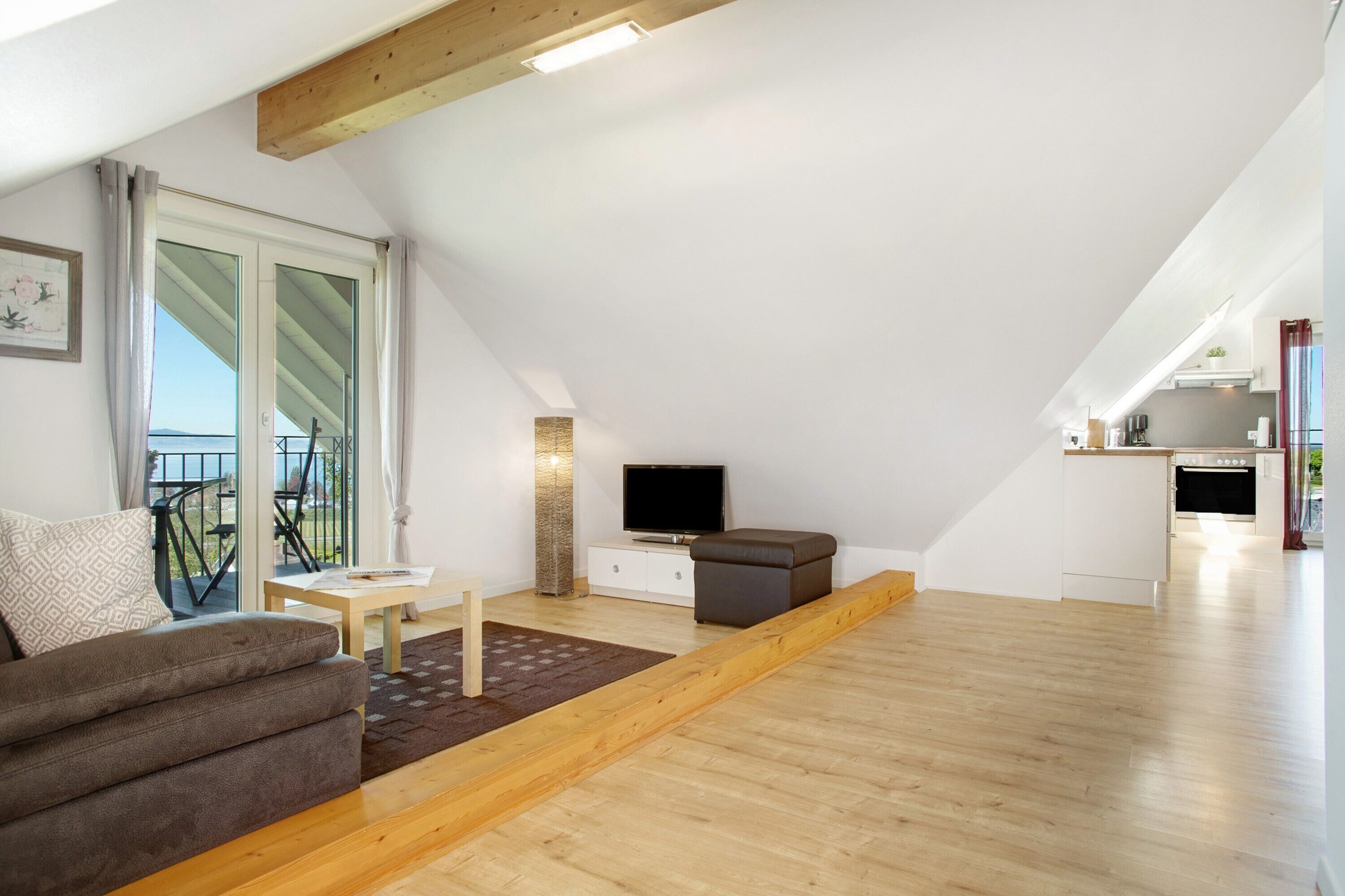 Ein modernes Loft-Apartment mit Essbereich, einer Couch, einem Fernseher und einer Küche.