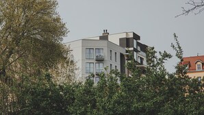 Un immeuble moderne à plusieurs étages, doté de balcons et de grandes fenêtres.