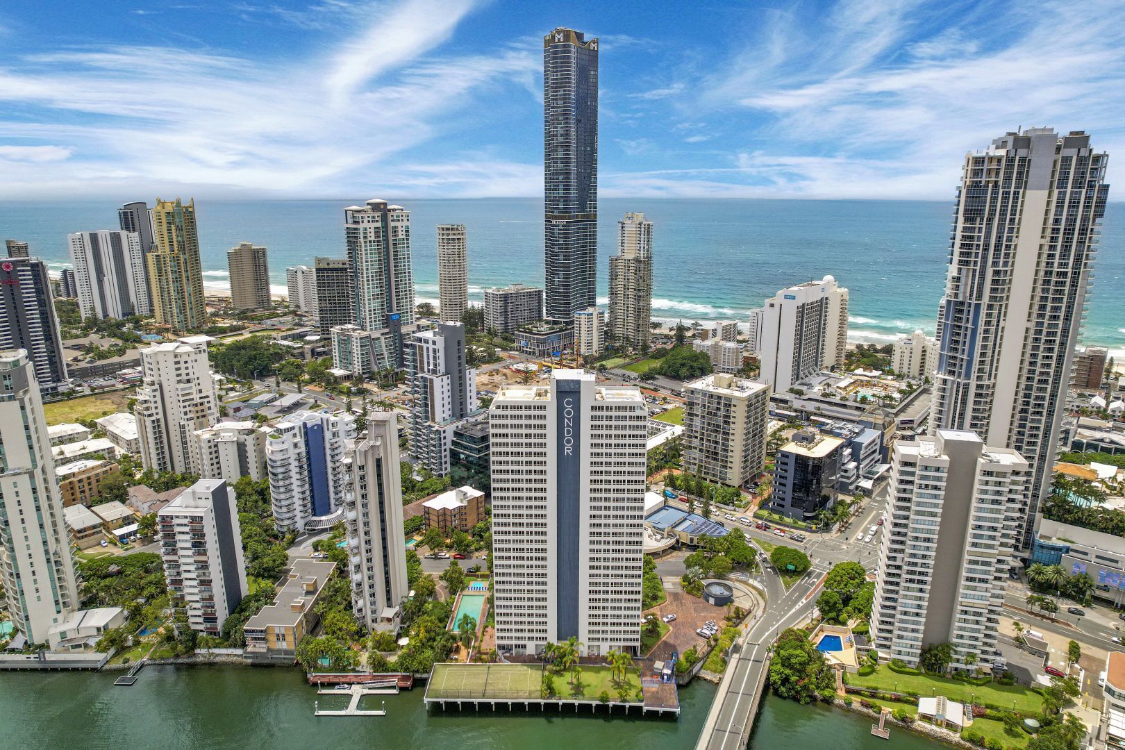 A high-rise urban area with modern buildings, a marina, and a clear view of the ocean.