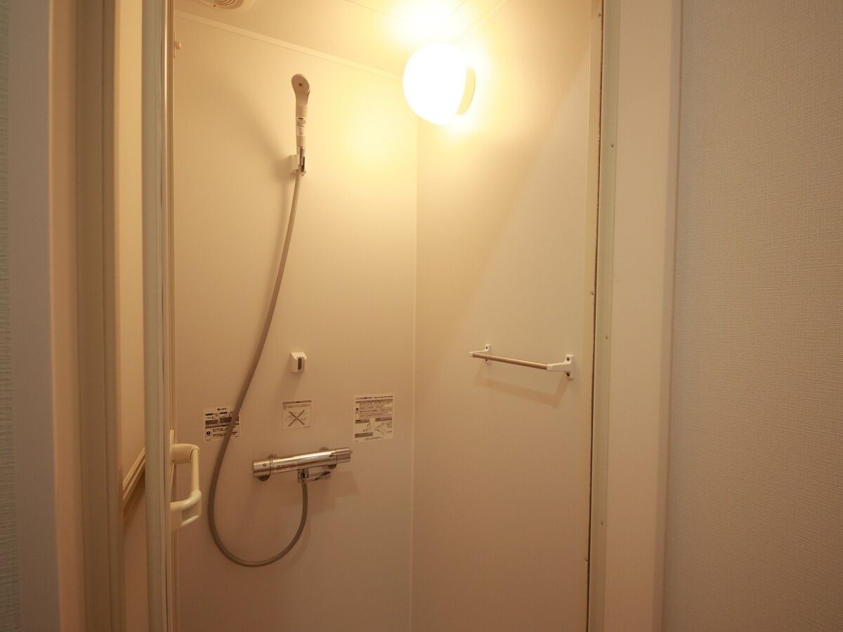 Un bagno con doccia, asciugamani ad aria e portasciuga.