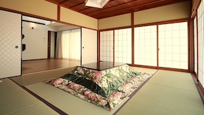 A tatami mat room with a low table and a shoji screen door. - Kaemon Ryokan (Takahama)