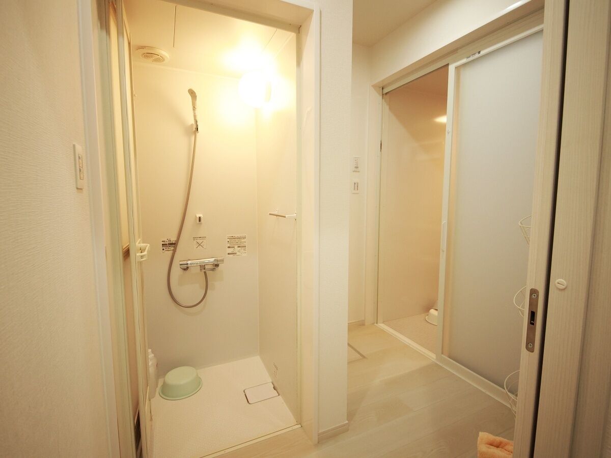 A small, compact bathroom with a shower, toilet, and sink.