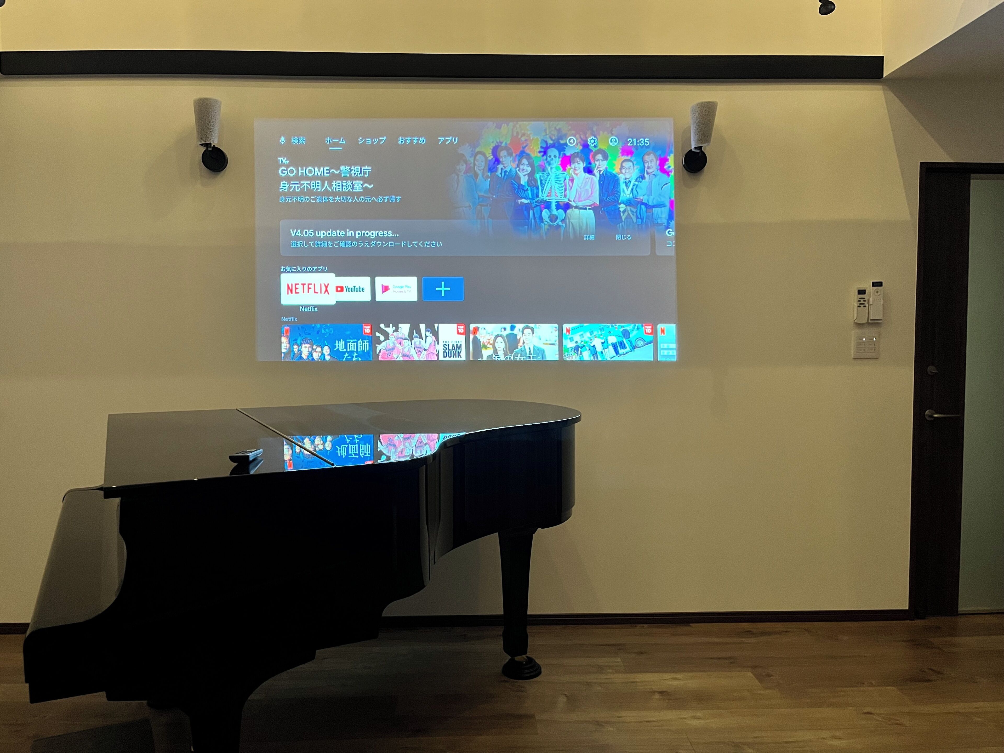 Una pantalla proyectando la interfaz de Netflix, con un piano en primer plano.