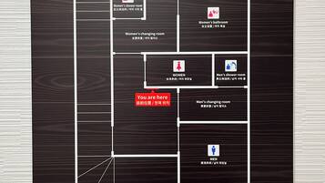 A hotel layout with women's and men's changing rooms, showers, and bathrooms.