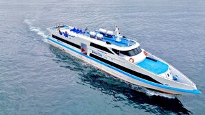 A large, modern cruise ship with a streamlined design, multiple decks, and a prominent blue and white color scheme. - Aman Dia Cruise (Serangan)