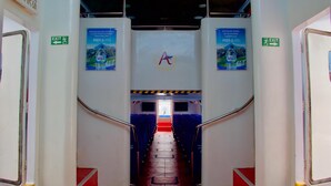 A corridor with blue seating, an exit sign, and a staircase leading to a platform. - Aman Dia Cruise (Serangan)