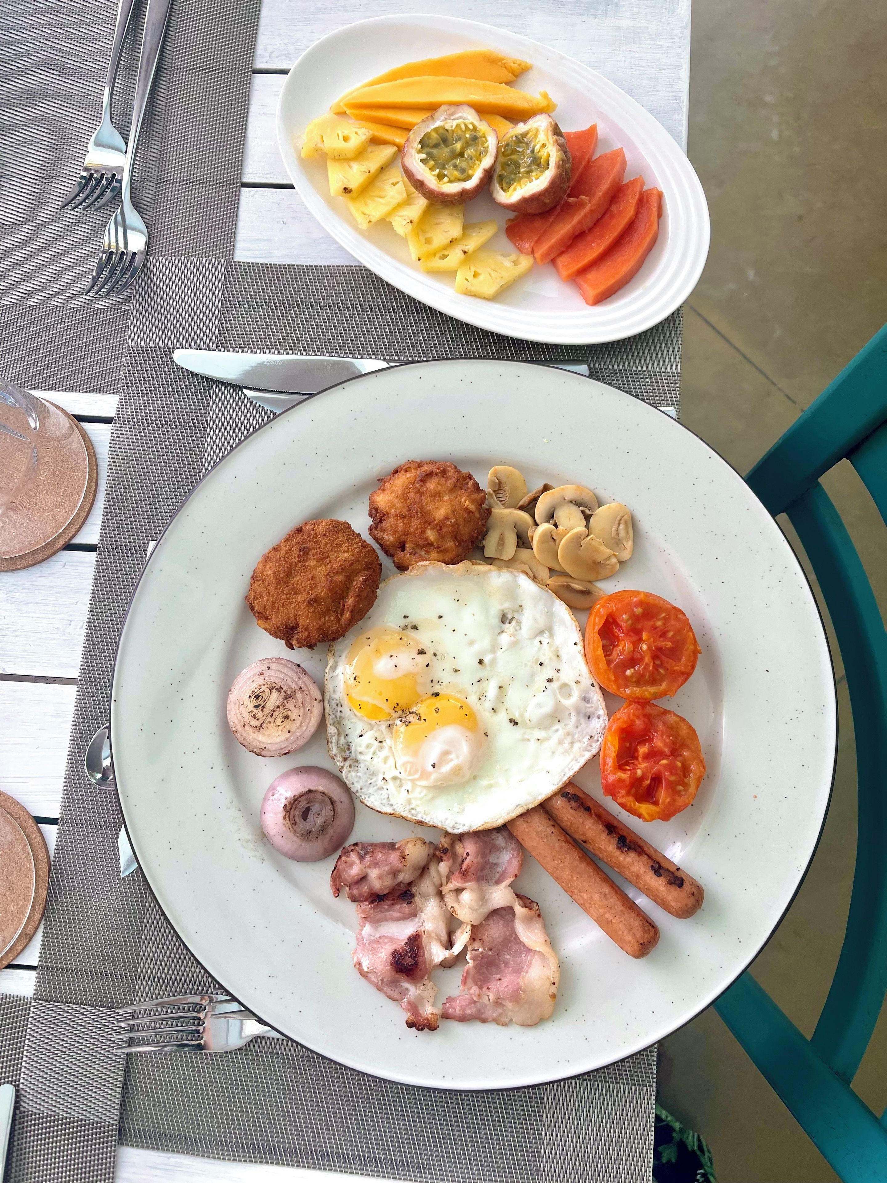 A breakfast plate with eggs, mushrooms, ham, and tomatoes.