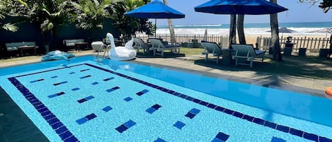 Piscine extérieure, parasols de plage, chaises longues