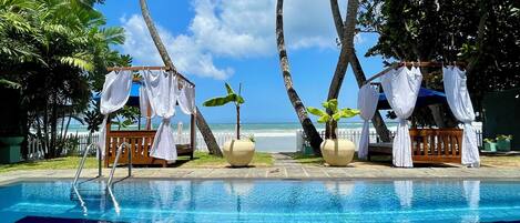 Alberca al aire libre, sombrillas en la alberca y camastros