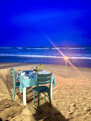 A table set for two on a beach with a view of the ocean. - Smeralda Beach Hotel (Batigama)