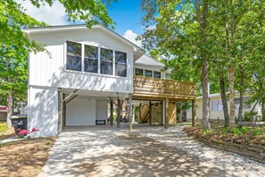 Een wit huis met twee verdiepingen, een overdekte patio en een garage.