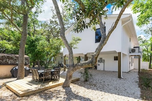 Une maison moderne dotée d’une terrasse, d’un espace salon extérieur et d’une cour en gravier.