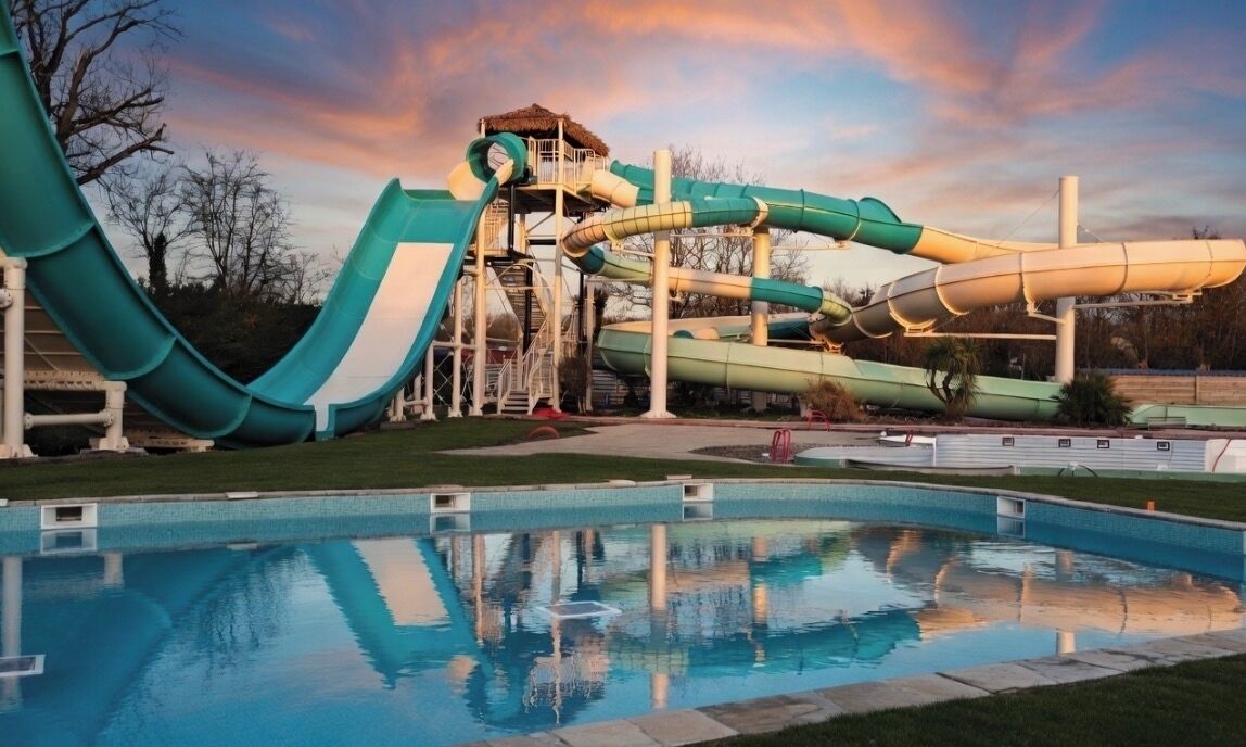 Parque acuático con una piscina grande y varias toboganes.