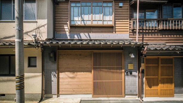 A traditional Japanese building with a wooden facade, large sliding doors, and a tiled roof.