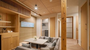 A modern interior with a sofa set, wooden paneling, and a kitchen area.