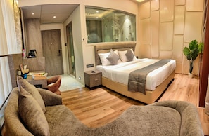 Un dormitorio moderno con una cama grande, una mesita de noche, un espejo y una planta en maceta.