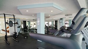 A gym with exercise equipment, a treadmill, and a weight bench. - Vacation getaway with beach access & balcony (CancÃºn)