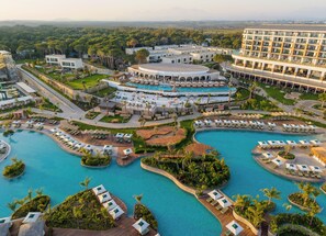 A resort with multiple swimming pools, a central circular pool, and a large building with balconies. - Ethno Belek (Serik)