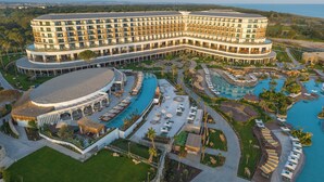 A large hotel with multiple swimming pools, a central courtyard, and a view of the surrounding landscape. - Ethno Belek (Serik)
