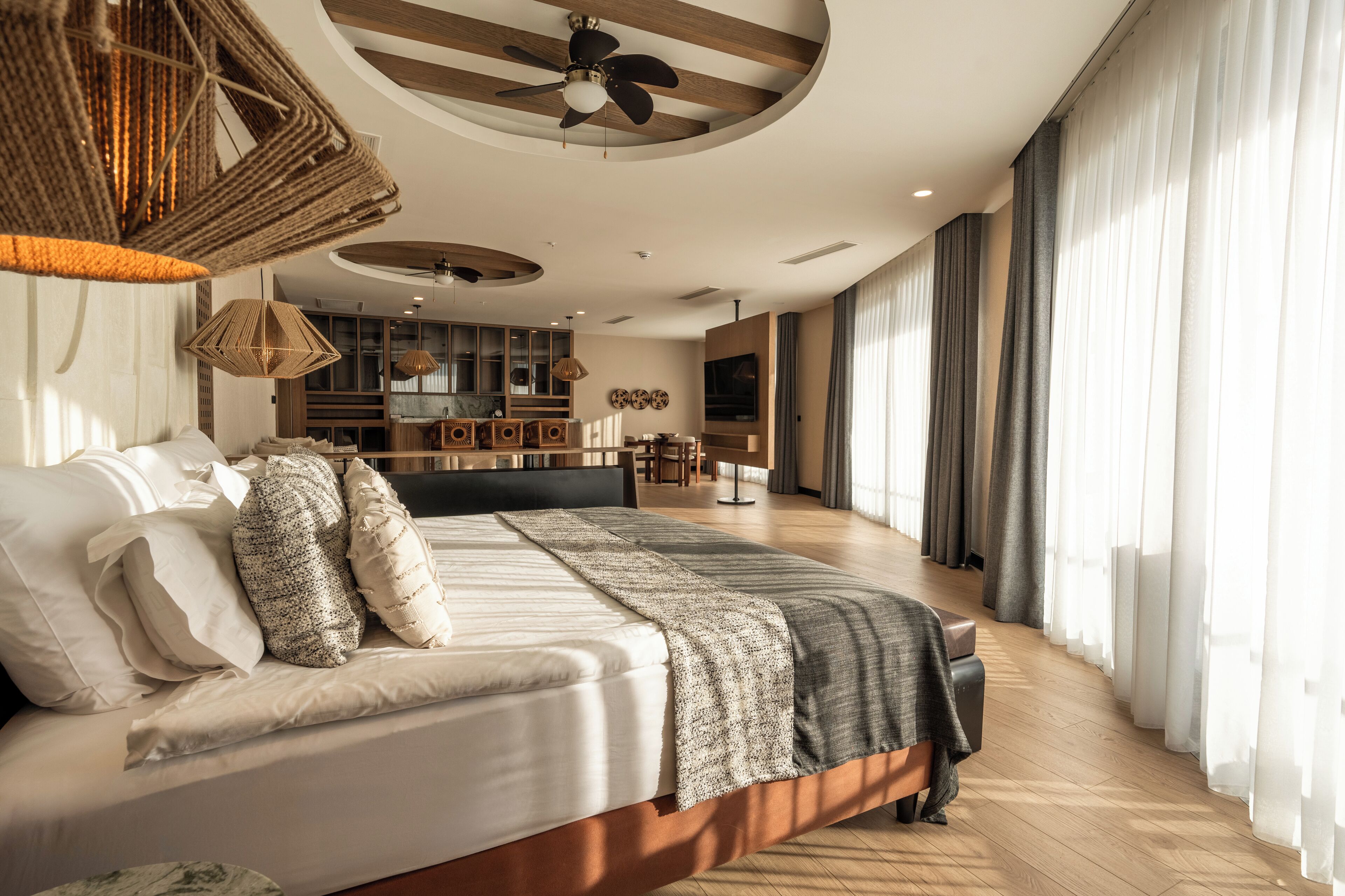 Un dormitorio moderno con una cama grande, un comedor y un televisor.