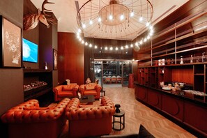 A modern interior with a leather sofa set, a television, and a chandelier.