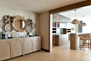 A modern kitchen with wooden cabinets, a central island, and a bar area with stools.